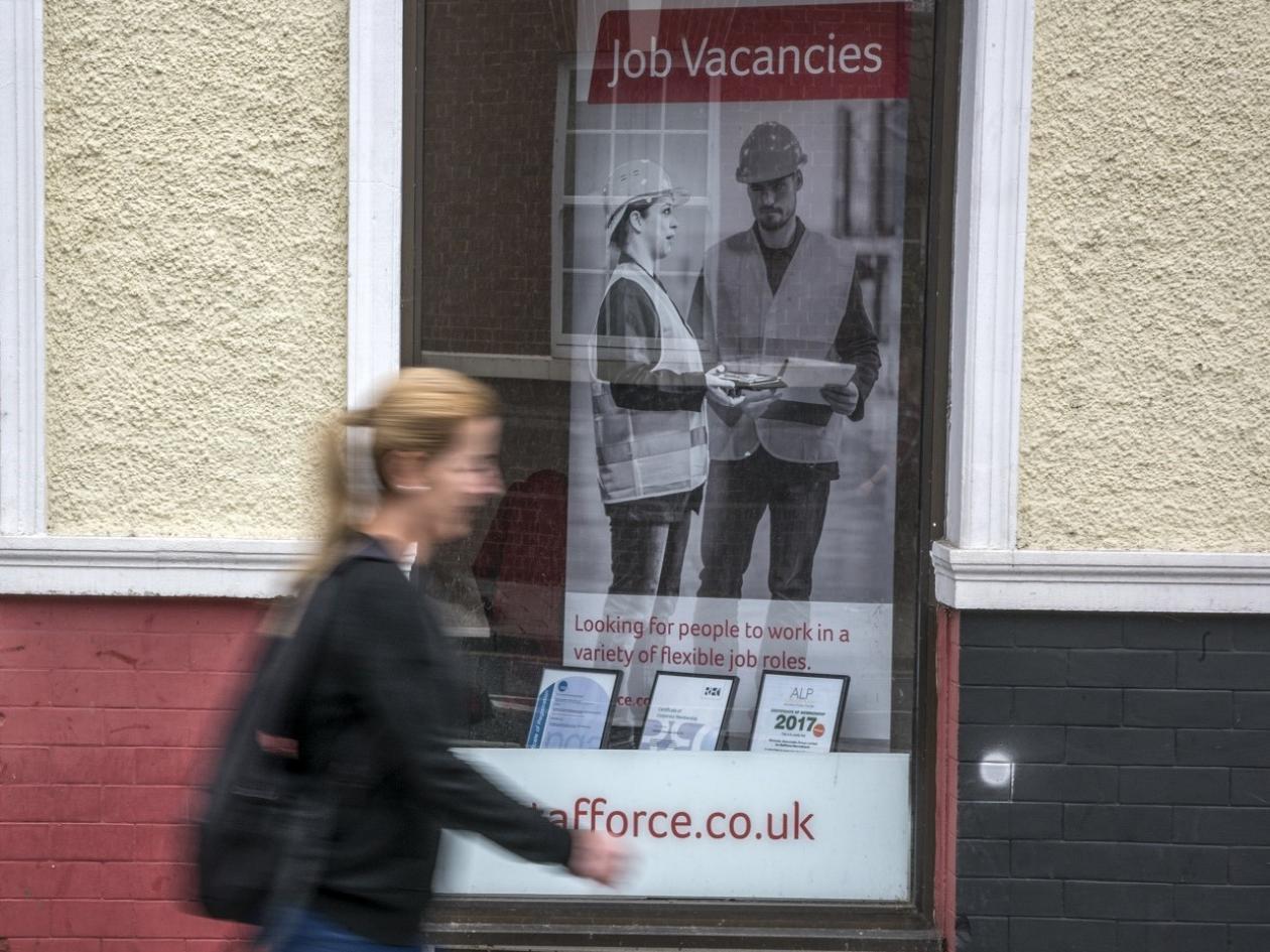 woman walking past job centre window