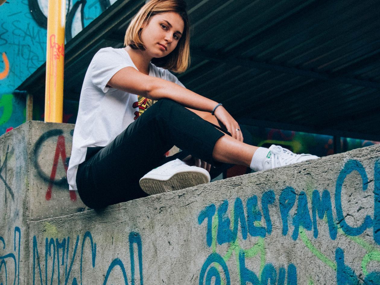 young woman sitting on wall