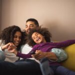 a smiling family on a sofa