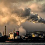 an industrial site with smoking chimney
