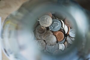 coins in the bottom of a jar. The coins are in focus, while the neck of the jar, nearer the camera, is blurred