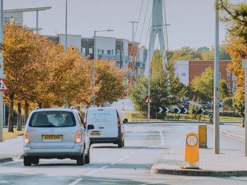 A white car braking behind a white van