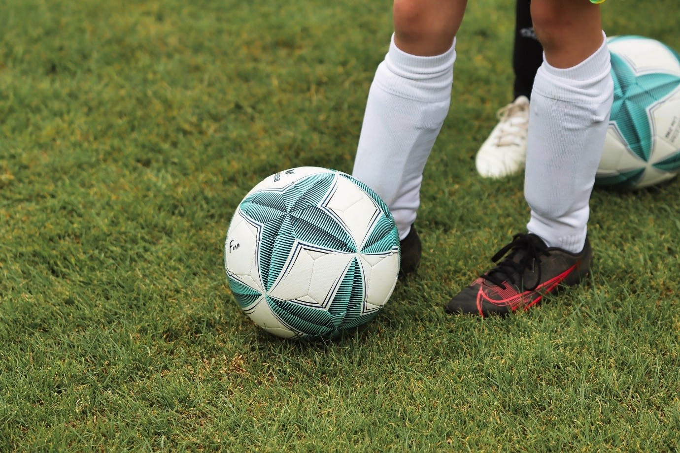 Image by Alexander Fox PlaNet Fox from Pixabay – close-up of a child/teenager’s feet and a football