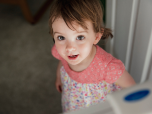 Photo of young child looking over a stair gate