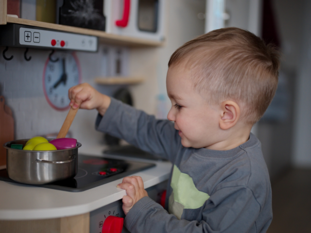 Small child playing in a toy kitchen