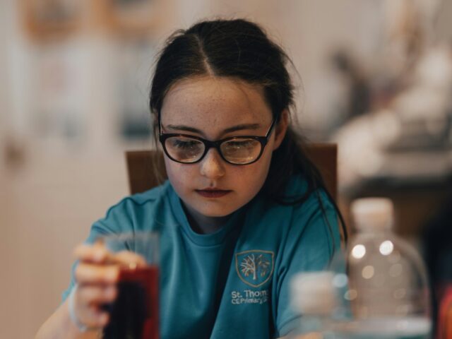 Girl in school uniform with glass of squash